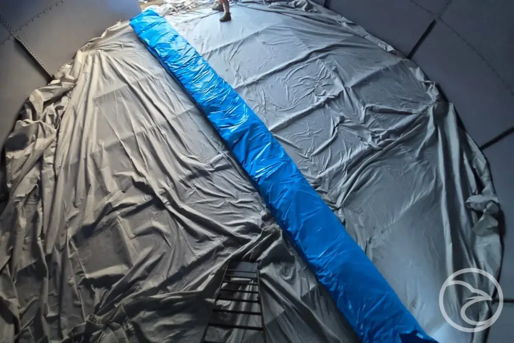 Technician providing tank liner repair service inside an industrial tank