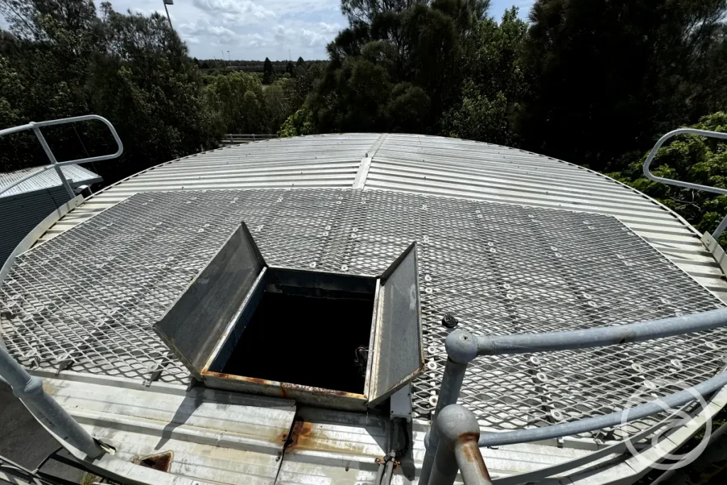 Industrial water tank with visible roof damage